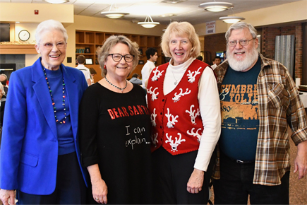 Four older adults at a Soaring Seniors luncheon